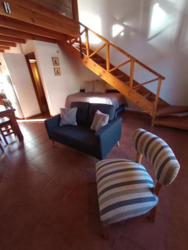 sala de estar con sofá azul y cama en Departamentos Turismo en San Martín de los Andes