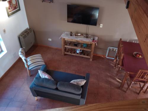 una vista aérea de una sala de estar con un sofá azul en Departamentos turismo en San Martín de los Andes