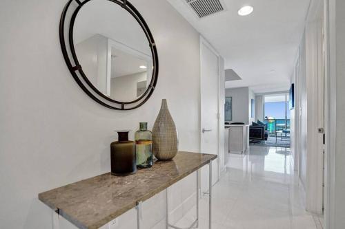 a hallway with a mirror and vases on a counter at Gorgeous 4 BDRM Condo Stunning Views Beach Access in Hallandale Beach