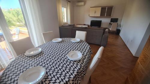 a table with two plates on it in a living room at Apartman Lana in Vir