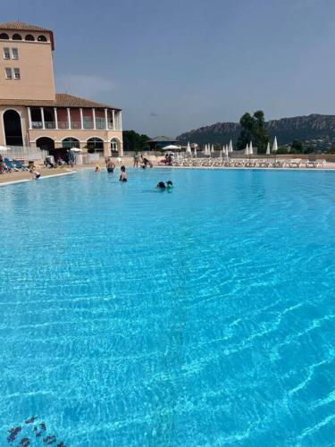 une grande piscine d'eau bleue avec des personnes dans l'établissement Cap Esterel le hameau au calme sans vis à vis vue mer terrasse couverte 2ème et dernier étage minimum de 7 nuitées, à Agay