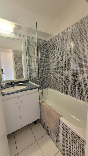 une salle de bain avec un lavabo, une baignoire et un miroir dans l'établissement Cap Esterel le hameau au calme sans vis à vis vue mer terrasse couverte 2ème et dernier étage minimum de 7 nuitées, à Agay