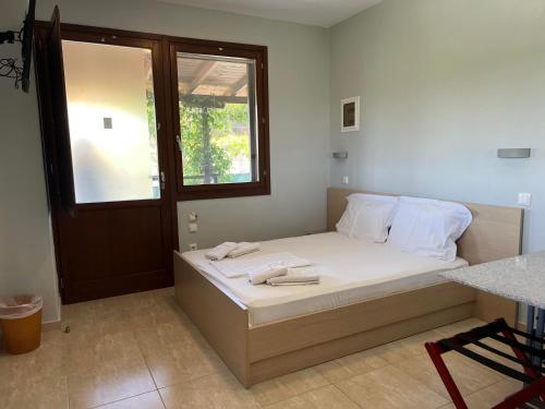a bedroom with a bed with white sheets and a window at Athos Bay Villa in Ammouliani