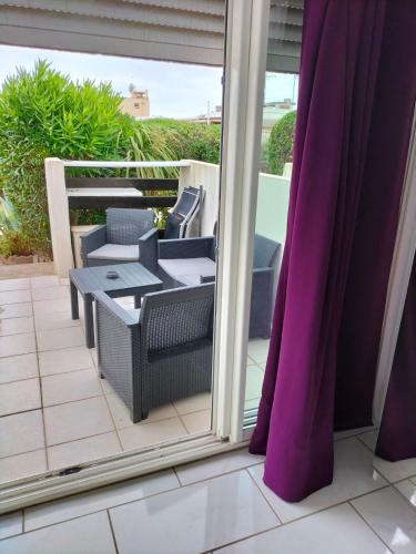 un patio avec une table et des chaises sur un balcon dans l'établissement PORT NATURE 2 Village Naturiste, au Cap d'Agde