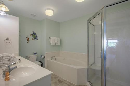 een badkamer met een douche, een wastafel en een bad bij Navy Cove Harbor 1205 by Vacation Homes Collection in Fort Morgan