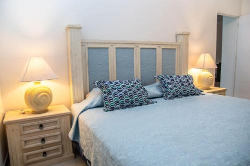 a bedroom with a bed with blue sheets and pillows at Casa Lana Central in Ajijic
