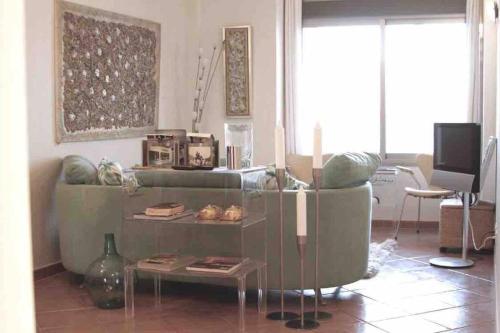 a living room with a green couch and a table at Experience beautiful duplex penthouse with terrace in Palma in Palma de Mallorca