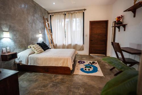 a bedroom with a bed and a ladder and a rug at Casa Monika in Puerto Escondido