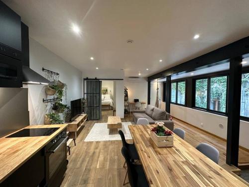 Il comprend une cuisine et un salon avec une table en bois. dans l'établissement T3 style loft, au calme, plein centre et climatisé, à Montpellier