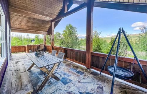 a screened in porch with a table and a swing at 4 Bedroom Gorgeous Home In Nord-Torpa in Nord Torpa