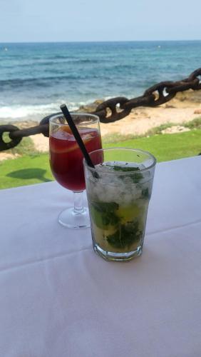 two drinks sitting on a table near the ocean at Apartamento Manolo,Punta Prima,400m from the sea & swimming pool in Torrevieja