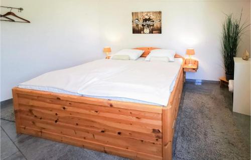 ein Schlafzimmer mit einem großen Holzbett mit weißer Bettwäsche in der Unterkunft 2 Bedroom Gorgeous Home In Lemmer in Lemmer