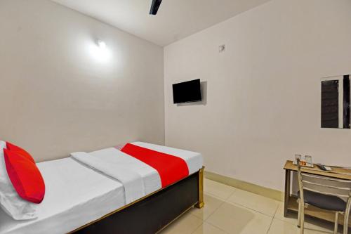 a bedroom with a bed and a desk and a tv at OYO Flagship 81047 Hotel Dream Inn in Gamhāria