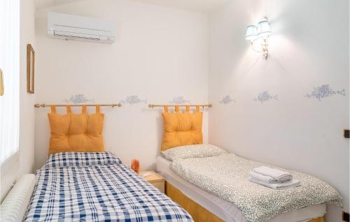 Habitación pequeña con 2 camas en azul y blanco en Awesome Home In Fanzolo Di Vedelago With Outdoor Swimming Pool, Private Swimming Pool And 5 Bedrooms, en Fonzolo