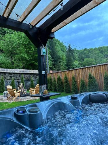 a backyard pool with a hot tub and an umbrella at Căsuța cu doi brazi in Baia Mare