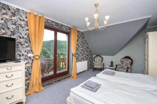 1 dormitorio con cama y ventana en Brenna-Dom z Basenem, Sauną i Jacuzzi, en Brenna