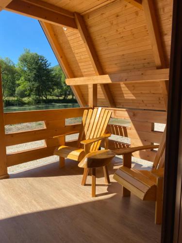 a porch with two wooden chairs and a wooden roof at Bungalow Jajce 1 in Jezero