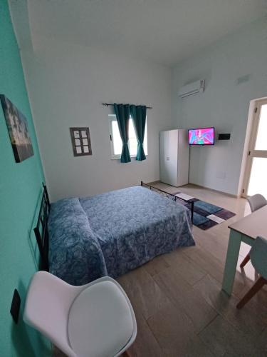 a bedroom with a bed and a refrigerator and a table at B&B Nonna Pina in Cirò Marina