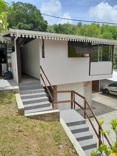 a house with stairs leading to a garage at La Poulette amazonienne in La Mauny