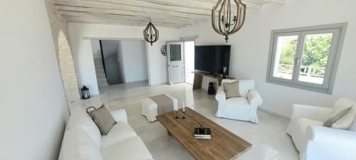 a living room with white furniture and a table at Villa celine in Aliki