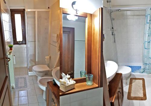 La salle de bains est pourvue de 2 toilettes, d'un lavabo et d'un miroir. dans l'établissement Villetta La Pigna, à Castel di Sangro