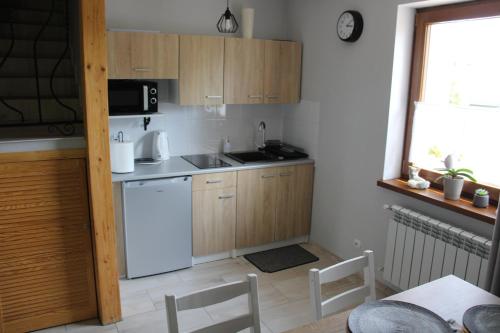 een keuken met houten kasten en een witte koelkast bij Apartament Karpetówka in Kluszkowce