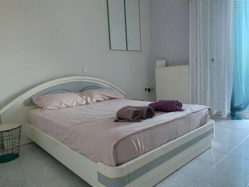 een wit bed met twee handdoeken in een slaapkamer bij Argostoli Apartment in Argostoli