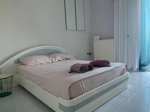 a white bed with two towels on it in a bedroom at Apartment Aura in Argostoli