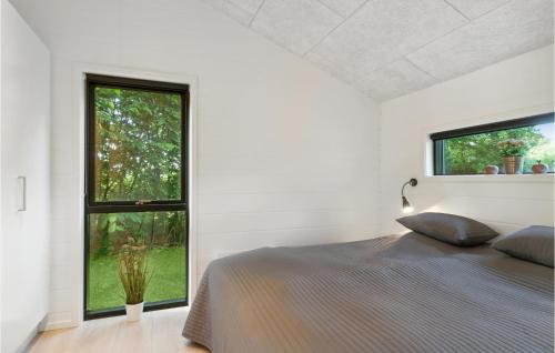 エーベルトフトにある4 Bedroom Awesome Home In Ebeltoftのベッドルーム1室(ベッド1台、大きな窓付)