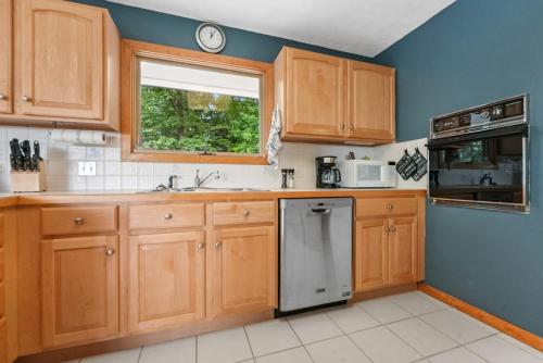 a kitchen with wooden cabinets and a sink and a window at Glen Lake Ridge in Empire