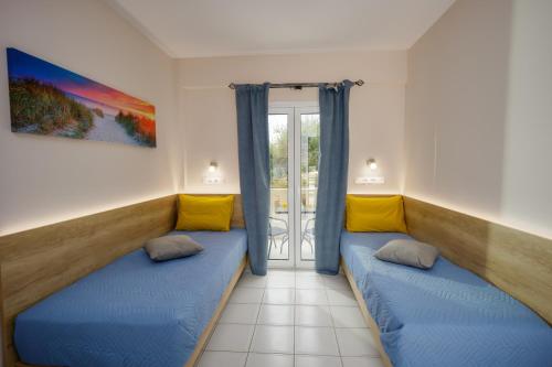 una sala de estar con 2 sofás azules y una ventana en Sofia's Apts en Hersonissos