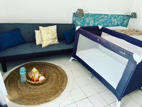uma sala de estar com um sofá e uma cesta de frutas em Koala Room em Le Diamant