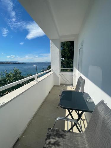 a balcony with a table and chairs and the ocean at Villa Lovorka by VILLA EVA in Omišalj