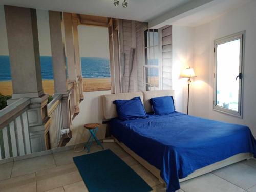 a bedroom with a blue bed with a view of the ocean at Studio du Lagon de Hammamet in Nabeul