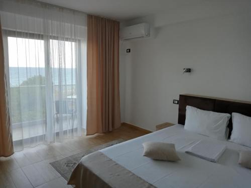 a bedroom with a large bed and a large window at Black Sea in Costinesti