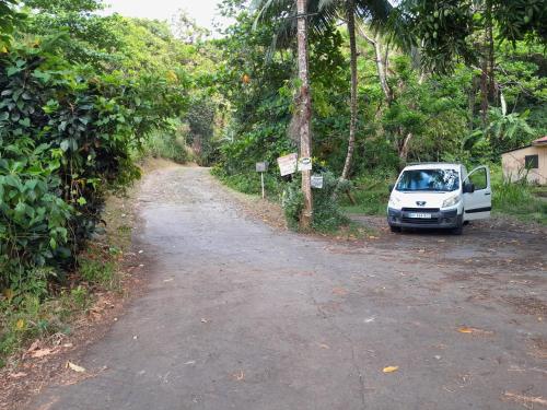 a white car parked on the side of a dirt road at La Poulette amazonienne in La Mauny
