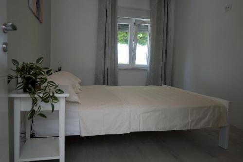 a bedroom with a white bed and a window at Apartment Twins in Šibenik