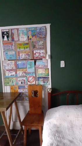 a bedroom with a table and a chair and a wall with books at Dormitorio Privado in La Cieneguita