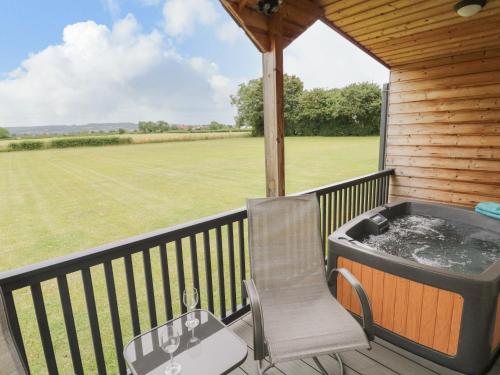 a deck with a chair and a hot tub at Cotswold View 2 in Evesham