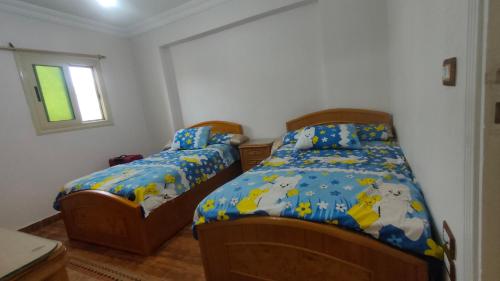 um quarto com 2 camas e uma janela em شقة مفروشة بالكامل بالإسكندرية تانى صف بحر em Alexandria