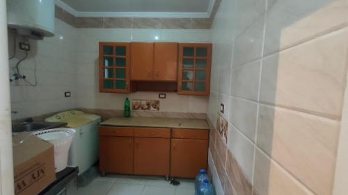 uma pequena cozinha com armários de madeira e um lavatório em شقة مفروشة بالكامل بالإسكندرية تانى صف بحر em Alexandria