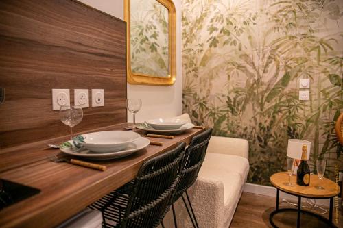 une salle à manger avec une table, des assiettes et des verres à vin dans l'établissement CosyRouen Bali Spa Hamman, à Rouen