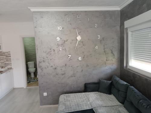 a living room with a couch and a clock on the wall at ATOS in Belgrade