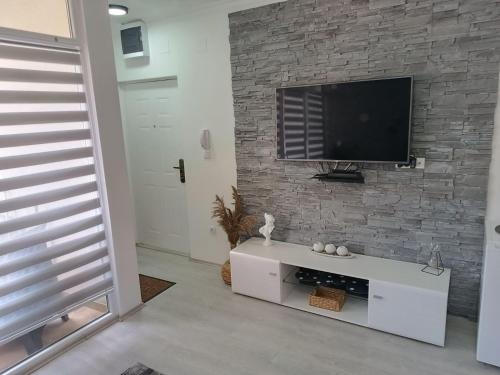 a living room with a tv on a brick wall at ATOS in Belgrade