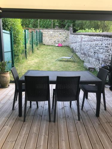 una mesa negra y sillas en un patio en Neuville secrete en Dieppe