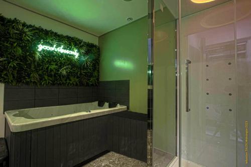 a bathroom with a tub and a green wall at CosyRouen Bali Jacuzzi & Hamman in Rouen