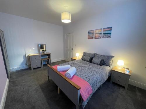 Schlafzimmer mit einem Bett, einem Schreibtisch und einem TV in der Unterkunft Marine Apartment Whitley Bay Seaside Location Free Onsite Parking in Whitley Bay