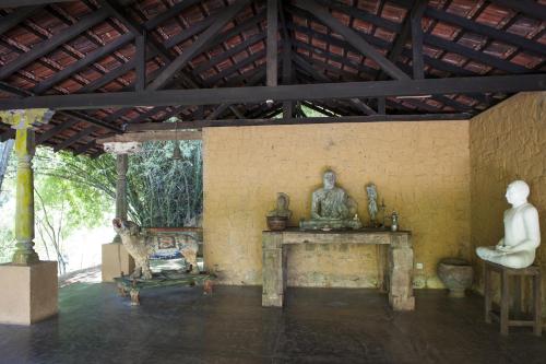 a room with statues on a table in a building at The Kandy Samadhicentre in Kandy