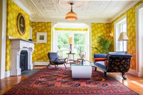 WaldoboroにあるThe Waldoboro Inn Room 5のソファと椅子と暖炉のあるリビングルーム