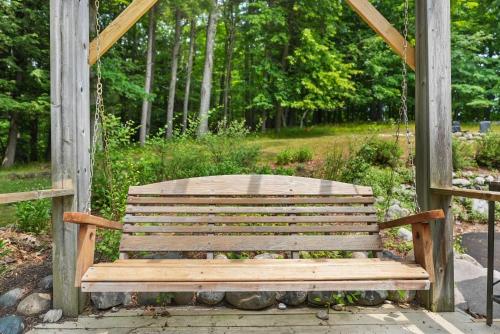 a wooden swing in a park with trees in the background at Glen Lake Ridge in Empire